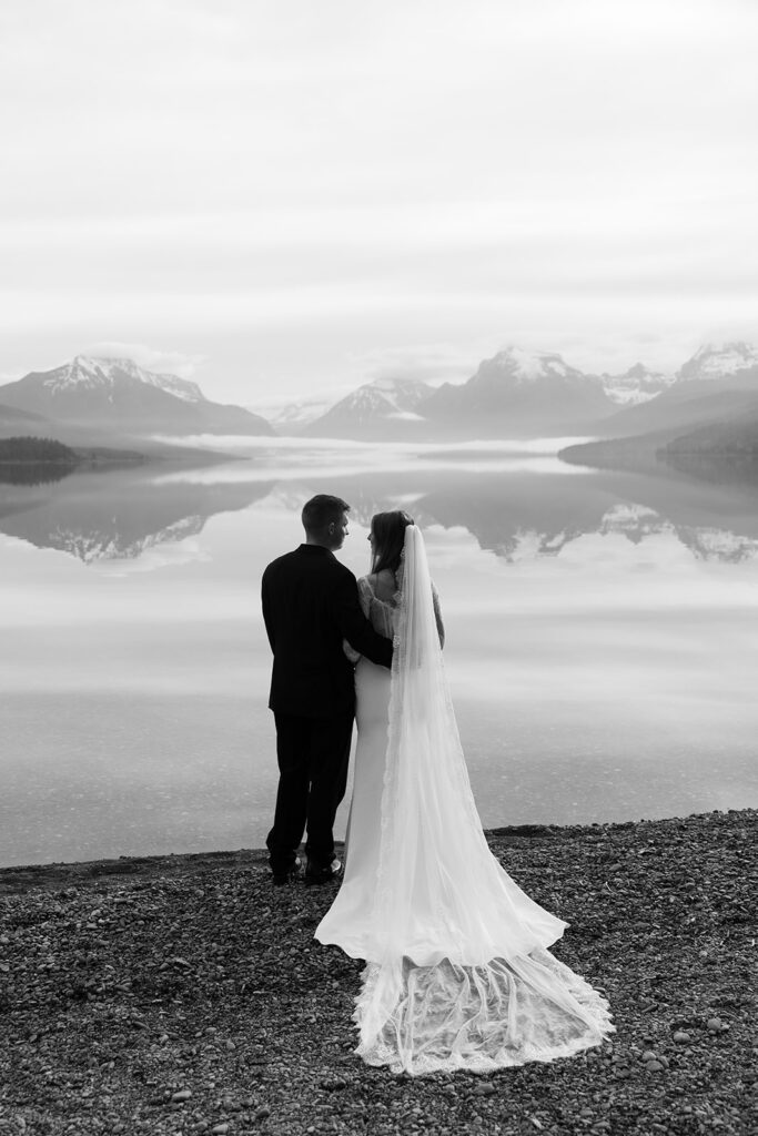 Couple embracing during an intimate Glacier National Park elopement surrounded by mountain scenery
