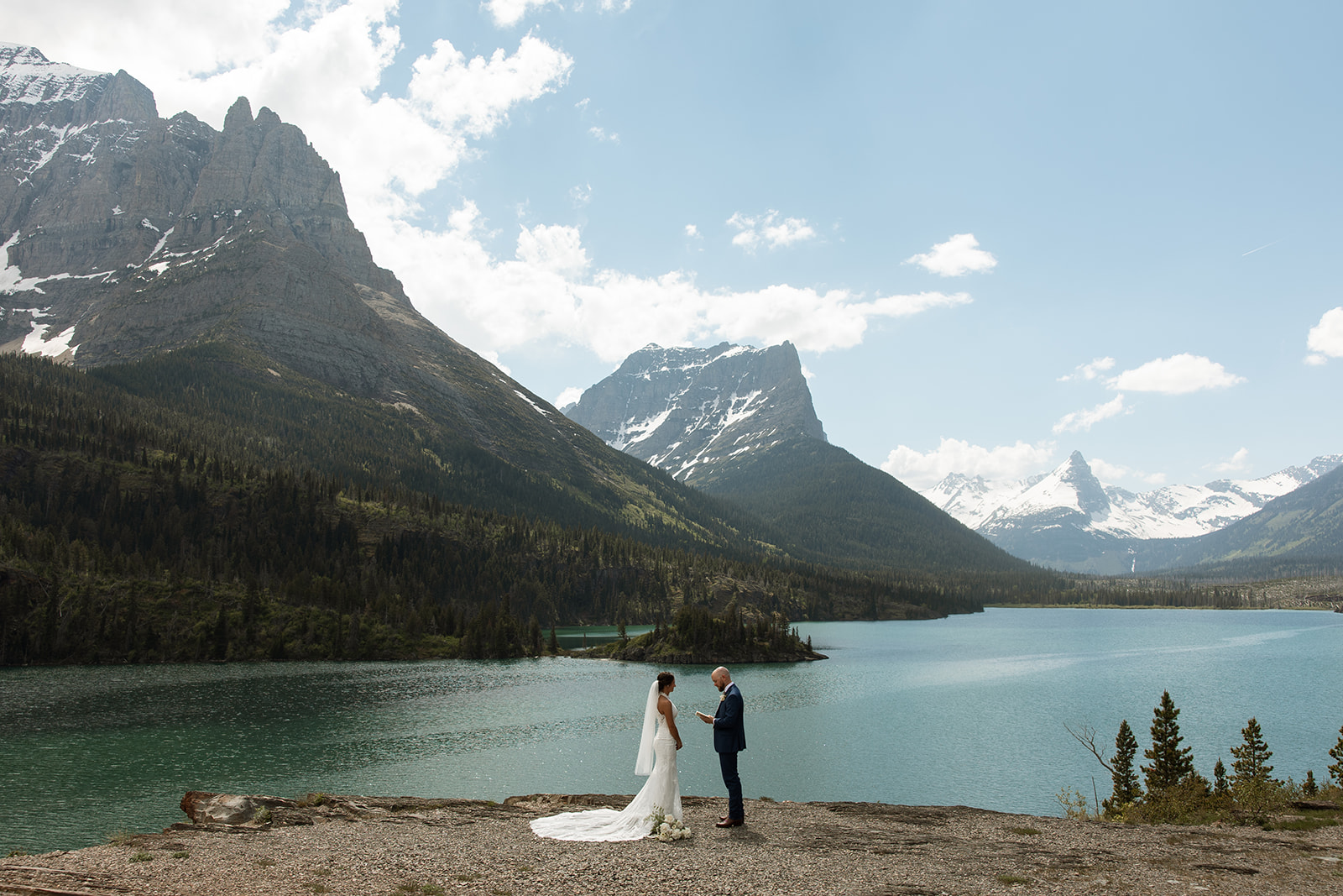 Couple embracing during an intimate Glacier National Park elopement surrounded by mountain scenery